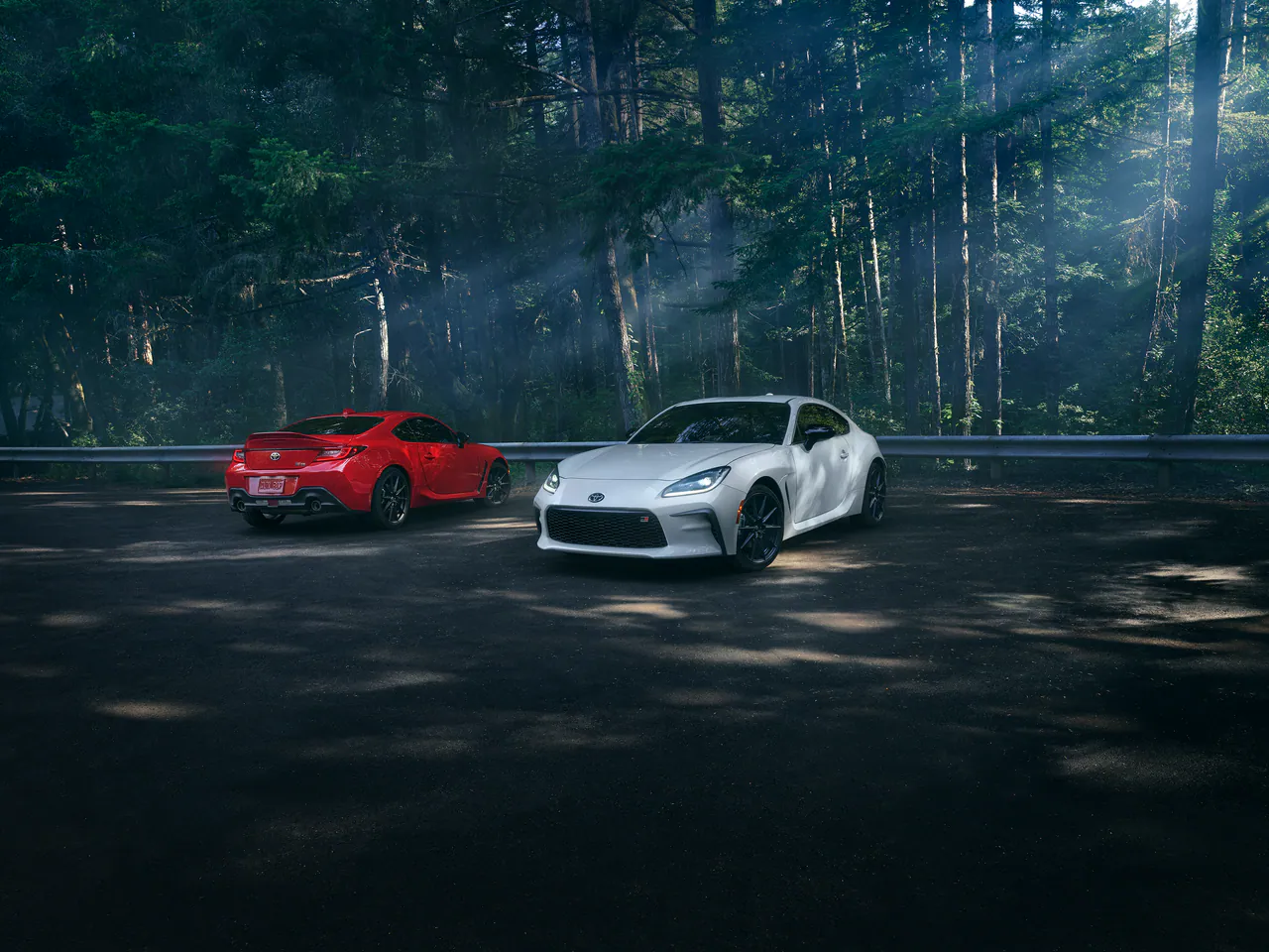 Two GR86 coupés in a forest clearing